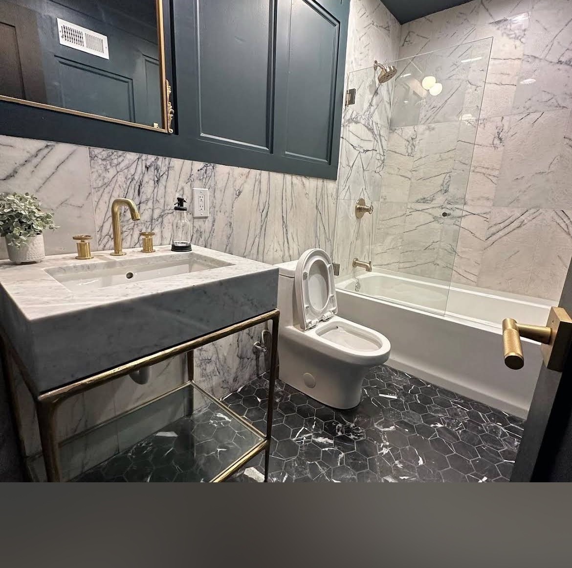Marble bathroom with brass fixtures, vanity and bathtub